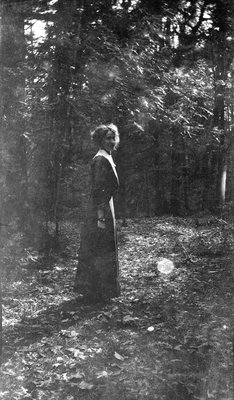 A woman standing in a forest clearing