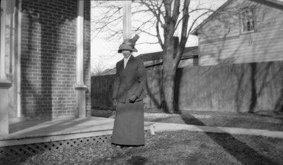 A woman standing in front of a house