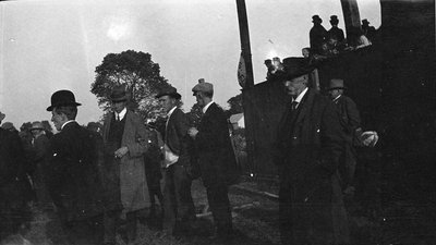 A group of men in front of a grandstand, possibly the races at Colborne fair