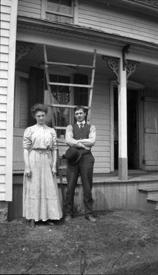 A young couple standing in front of a house