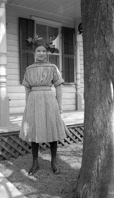 Gertie Mikle posing in front of a house