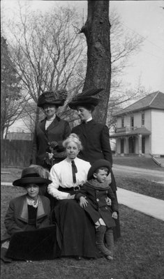 Four women and a young boy posing outside