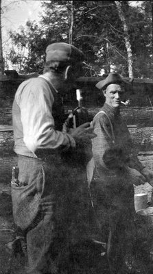 Two men in front of a camp