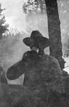 A man having a drink in the woods