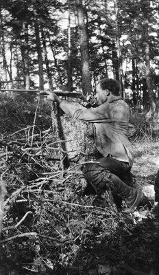 A deer hunter firing a rifle