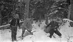 Deer hunters transporting a slain deer in winter