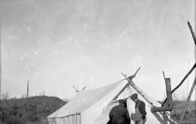 Two deer hunters standing in front of a tent