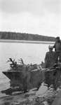 Hunters transporting slain deer by boat