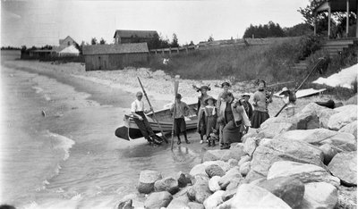 A woman and children preparing to go boating at Loughbreeze Beach