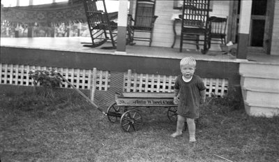 A young boy with his wagon outside the Griffis' summer house