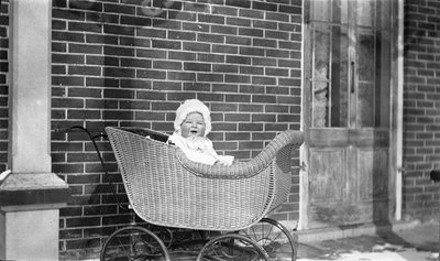 Baby in a wicker carriage on the Griffis? house porch