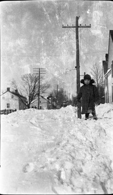 A child standing on a high snowbank