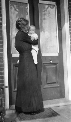 Griffis family photo of a woman and baby standing at a front door