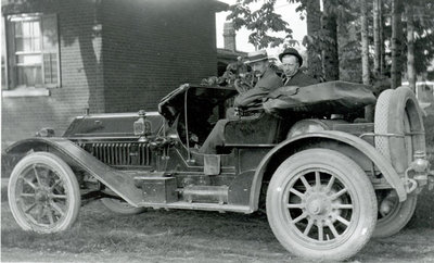 Driver and passenger in a 1910s car