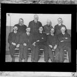 Nine men posing for a photograph