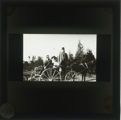 Henry Gale and two other people riding in a horse drawn carriage