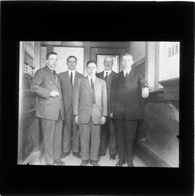 Five bank employees posing inside a bank