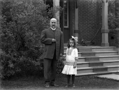 Anglican Reverend and a young girl outside the Rectory, Colborne