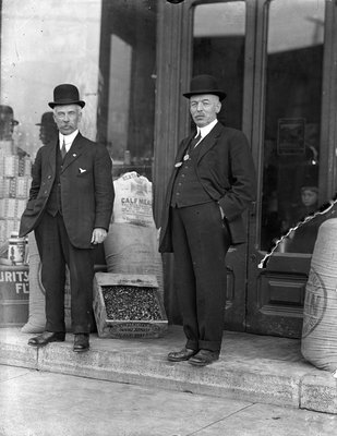 Two men standing in front of ?W.H. Edwards grocery store, Colborne