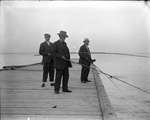 Three men fishing off a wharf