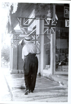 Man sweeping sidewalk, Griffis Drug Store, Colborne, Cramahe Township