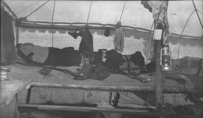 Deer hunters resting inside their camp tent