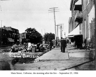 Furniture and other goods salvage from the smoke and fire line the edge of the street.