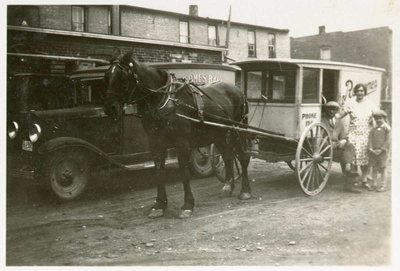 Everet Rowsome, Mrs. Rowsome and Charles in front of a Rowsome's Bakery horse drawn wagon and a Rowsome's Bakery Truck, Colborne