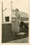 Nellie (nee Hodges) Maskell holding her niece, Jane Hodges (now Thrower) behind the Colborne United Church, ca. 1937