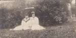 Two young women sitting outside