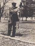 Man, possibly James Bawden or George Usborne, pulling the rope of the town bell, Victoria Park, Colborne, Cramahe Township