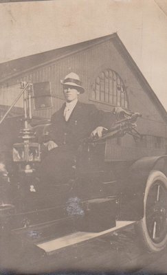 Man sitting in a car, ca.1915