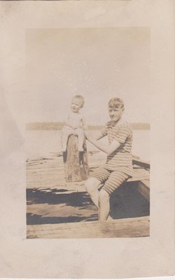 Postcard of a boy and a child sitting on a dock