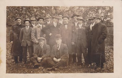 Postcard of a group of men in a backyard