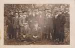 Postcard of a group of men in a backyard