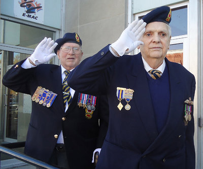 WWII veteran Don Prentice, left, and former RCAF pilot Dick Newman, right, took the salute from the steps of the Colborne Post Office as the Remembrance Day parade retreated from ceremonies in Victoria Square Park Nov. 11, 2014.