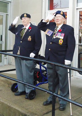 Jack Heighton, left, and Don Prentice take the salute at the Colborne Post Office after the Remembrance Day service at the Colborne Cenotaph Nov. 11, 2012.