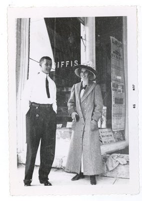 Photograph of an unidentified woman and man standing in front of Griffis drug store, 1910s, Colborne Women's Institute Scrapbook