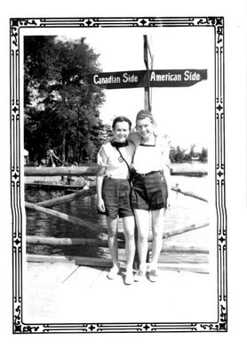 Two girls pose for a photo on the boardwalk at Stanley Park. 1938