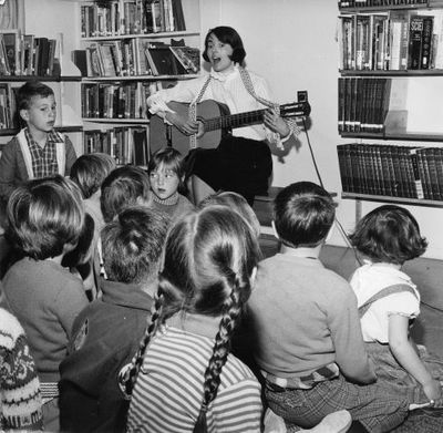 Georgetown Public Library - Librarian Anne Anderson entertaining children by singing and playing guitar.