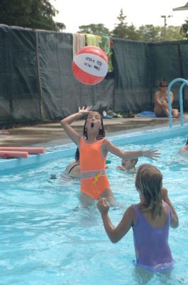 Two girls toss a beach ball between them at the Acton Wading Pool in  Prospect Park.