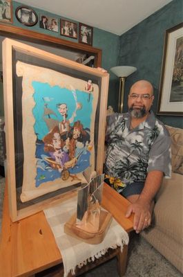 Lar DeSousa proudly displays one of his artworks that garnered him the  Aurora Award by the Canadian Science Fiction and Fantasy Association.