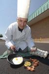 Sam Govas of Ares Restaurant, tries frying an  egg on the pavement.