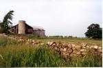 A dry stone wall and the barn on 9th Line north and 17 Sideroad.