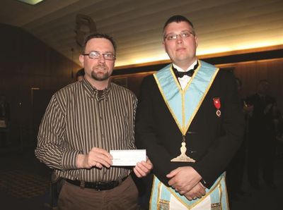 Senior Warden Brother Tom Allen presents cheque to president of Autism Ontario Halton chapter.