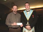 Senior Warden Brother Tom Allen presents cheque to president of Autism Ontario Halton chapter.