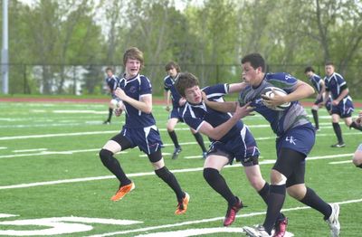 Nick Cunha takes on Callaghan Murphy and Cory Carpenter during Halton High School junior rugby match.