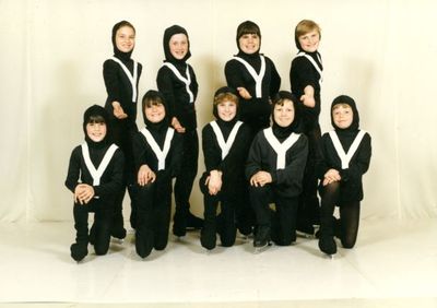 Eight boys from the Georgetown Skating Club dressed in black and white costumes