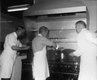 Dave Bowman watches Art Roberts and Ron Lincoln prepare a meal