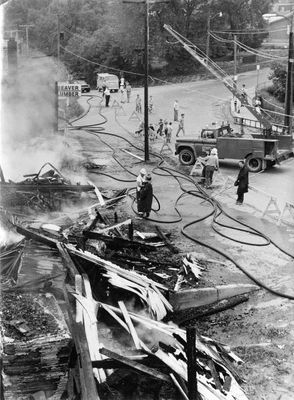 Firemen stream water on smoking ruins of Beaver Lumber warehouse